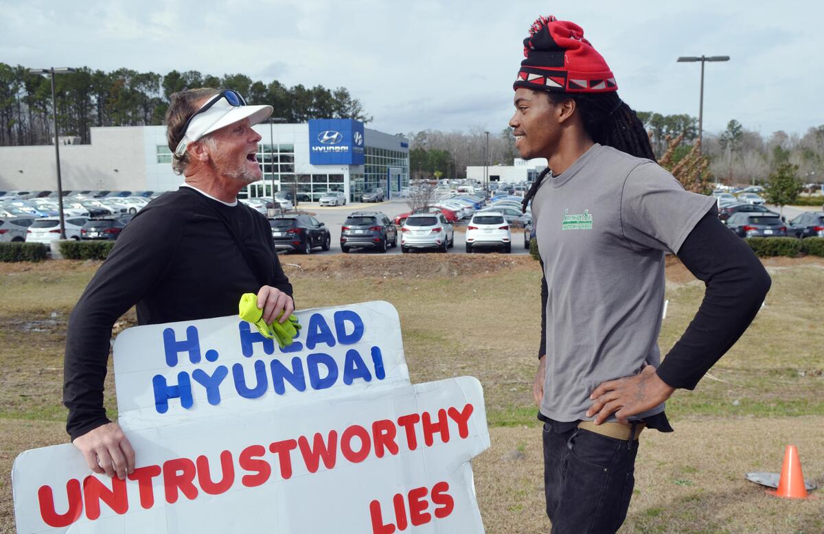 Greg Sanford Hackney talks with a motorist who stopped on Feb. 7 to find out why Hawkins was protesting outside Hilton Head Hyundai. Hackney says curious passersby frequently stop to ask him what he’s doing. “I hope he gets some justice,” said the motorist after listening to Hawkins’ story, “I hope something happens for him.”