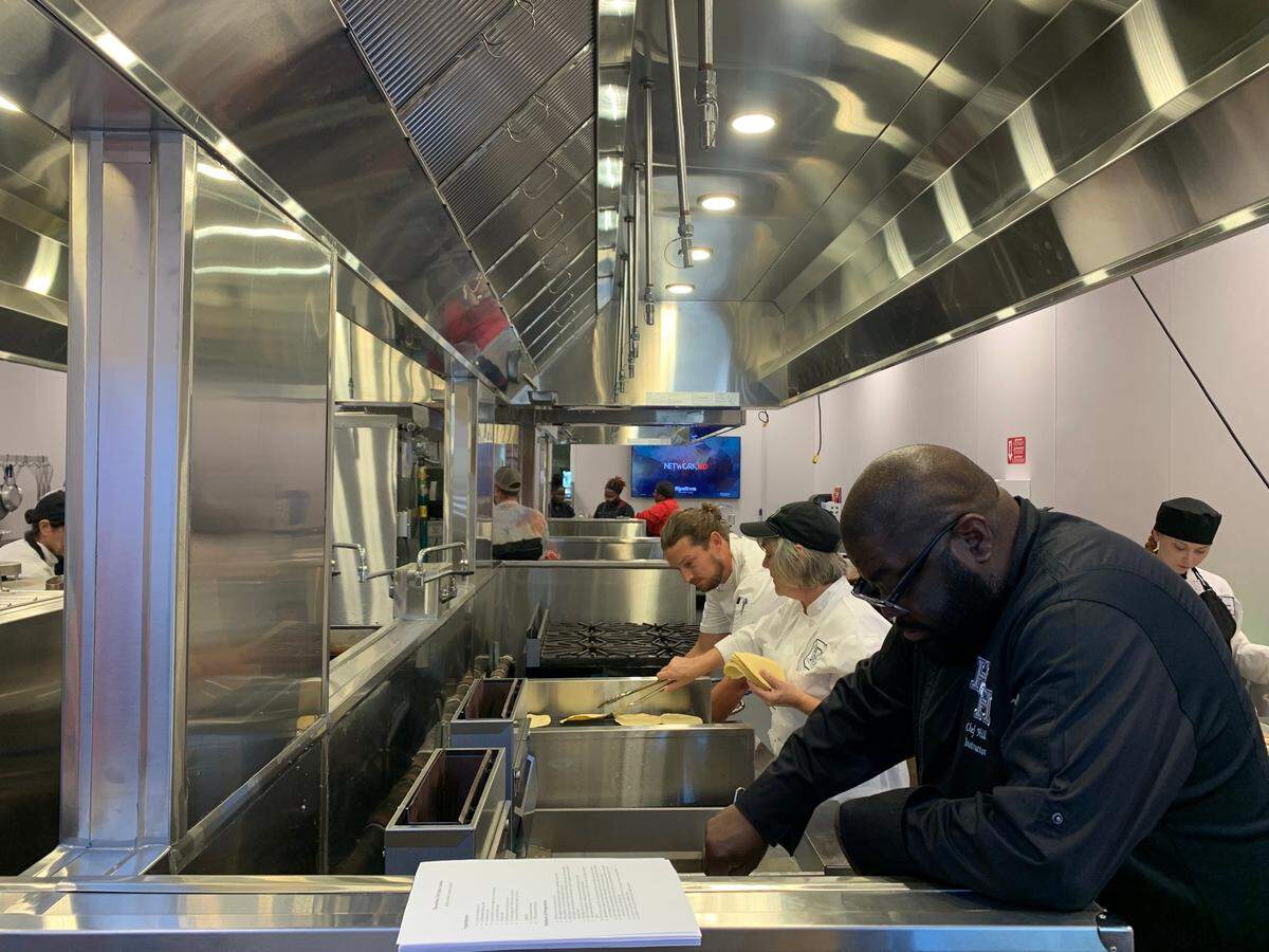 High school culinary teachers working to prepare the three-coure meal