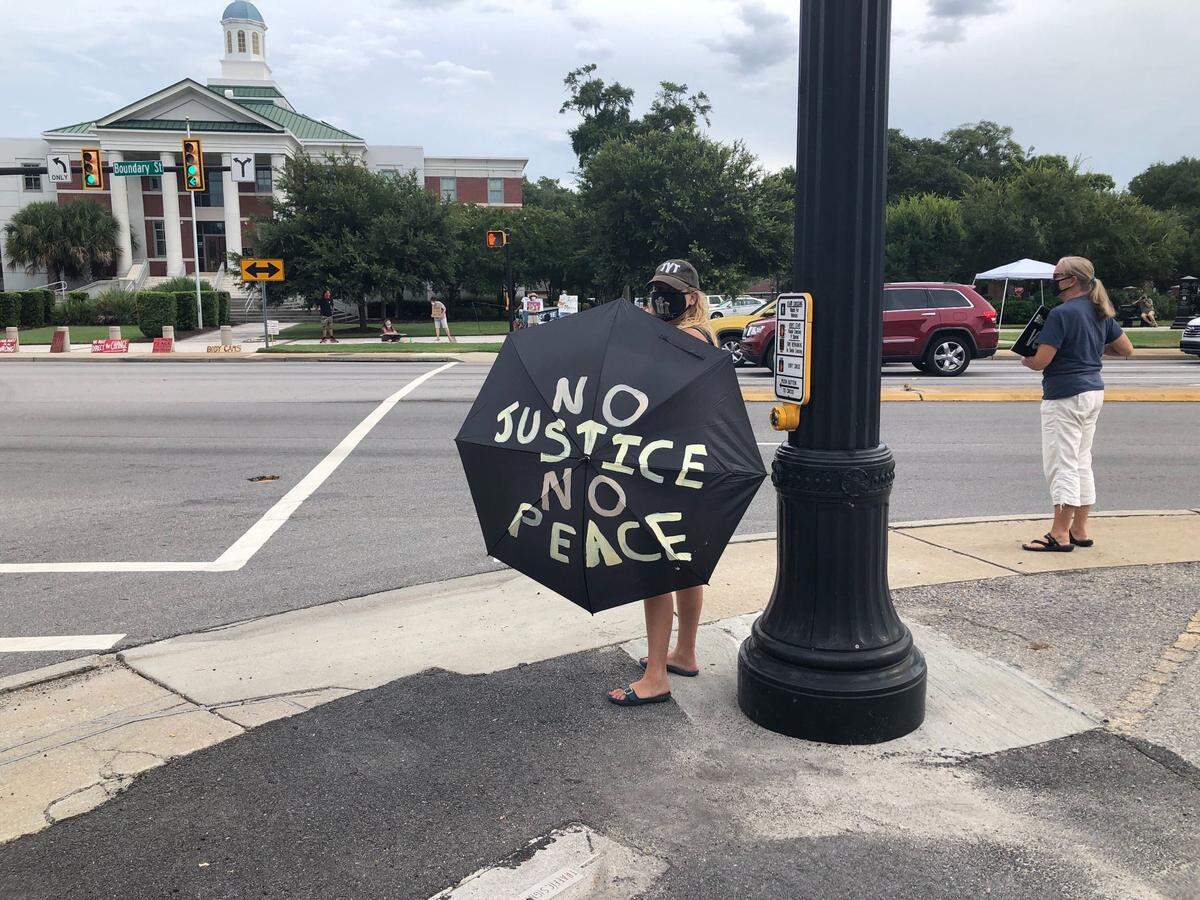 Courtney Cadien carries a sign reading “No Justice No Peace” at the rally for Trey Pringle Saturday in Beaufort.