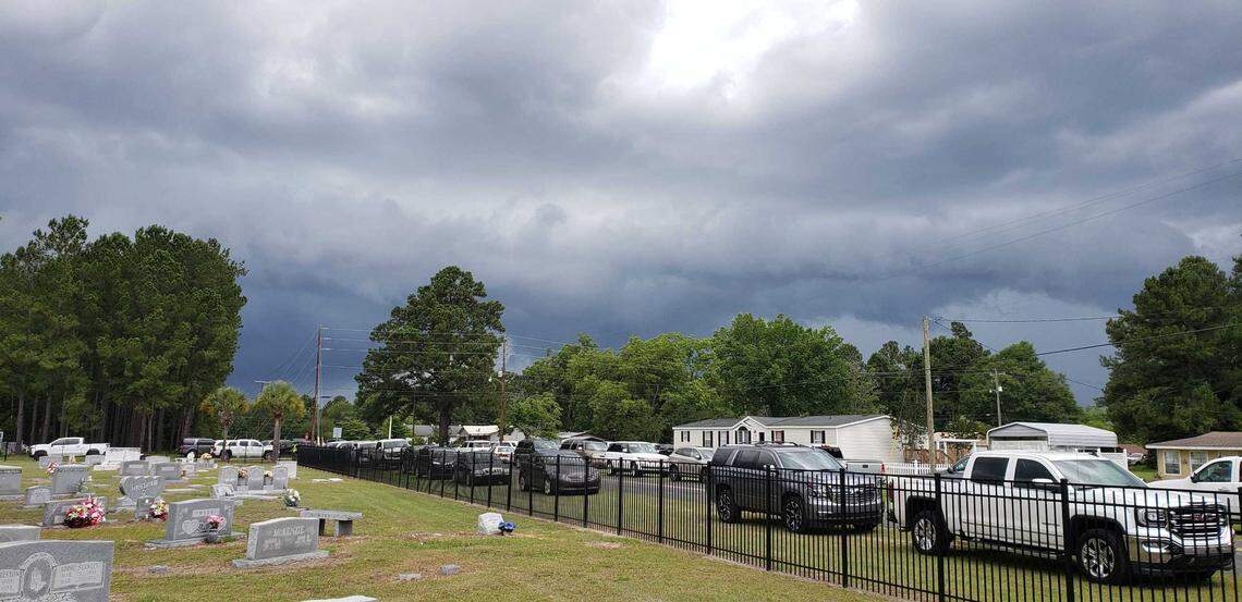 Vehicles parked nearby the funeral at the Hampton Cemetery for the funerals of Paul Murdaugh and his mother Maggie. Storm clouds loom.