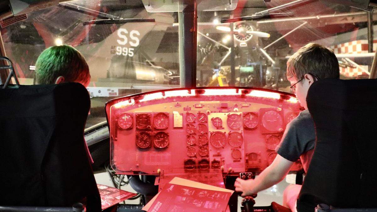 Two young visitors to the Museum of Aviation in Warner Robins, Georgia, enjoy hands-on exhibits, like this helicopter display.