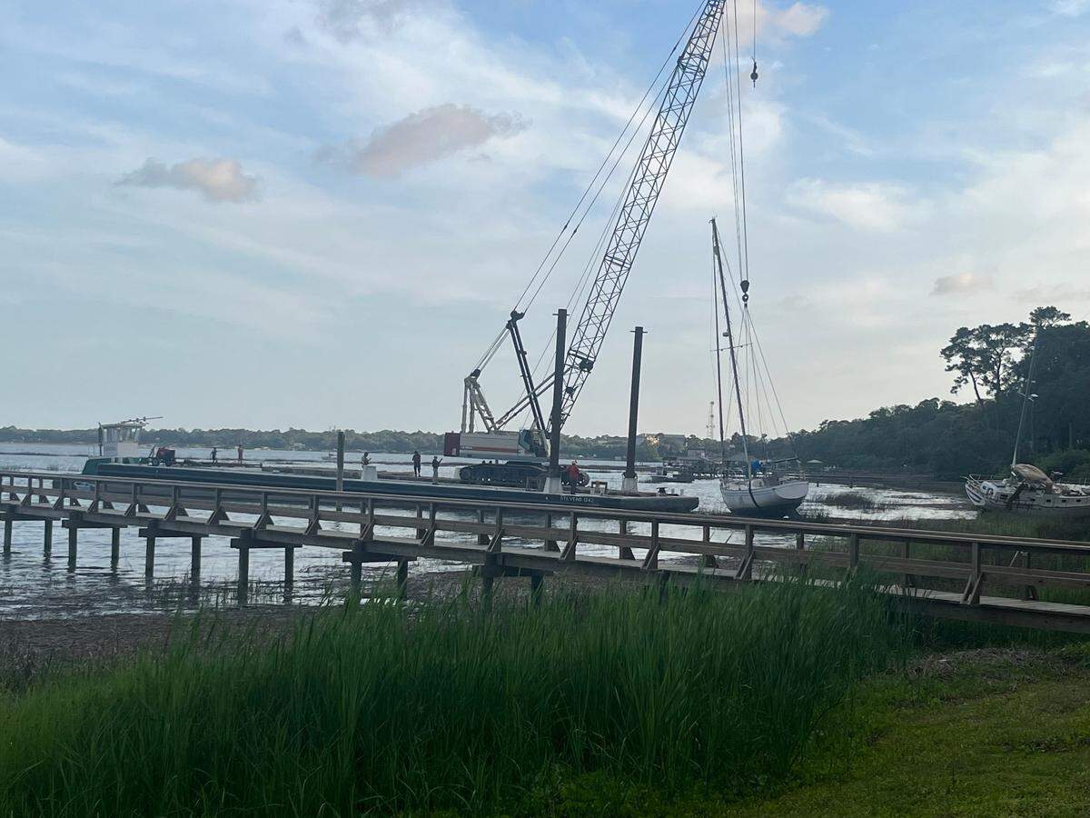 O’Quinn Marine hoists a 35-foot sailboat from the muddy banks of the Beaufort River Thursday evening. It was one of several that Tropical Storm Helene beached in September.