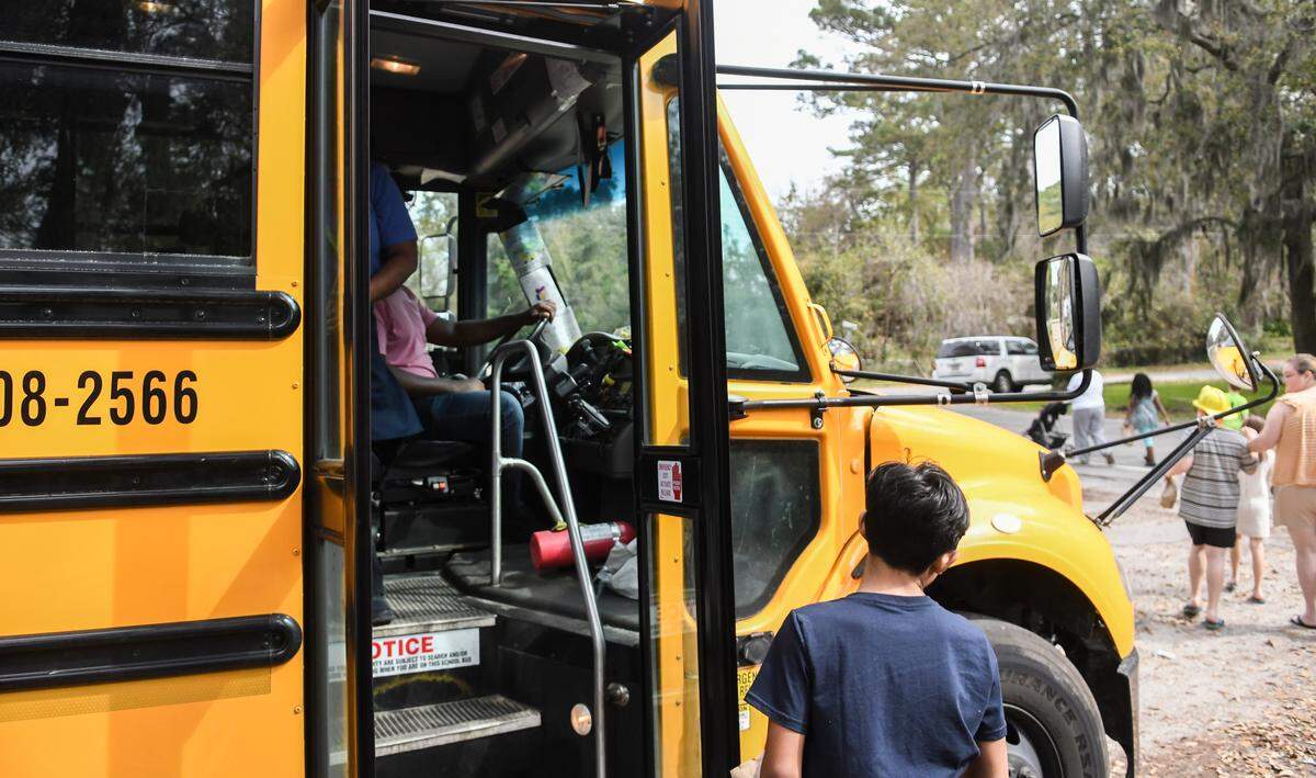 A student waits for a Sodexo employee to retrieve a lunch from the Beaufort County School District bus on Tuesday, March 17, 2020 in Bluffton on Crestwood and Shad avenues. The Beaufort County School District added several mobile bus stops throughout the county to deliver food during the COVID-19 pandemic for families with transportation issues.