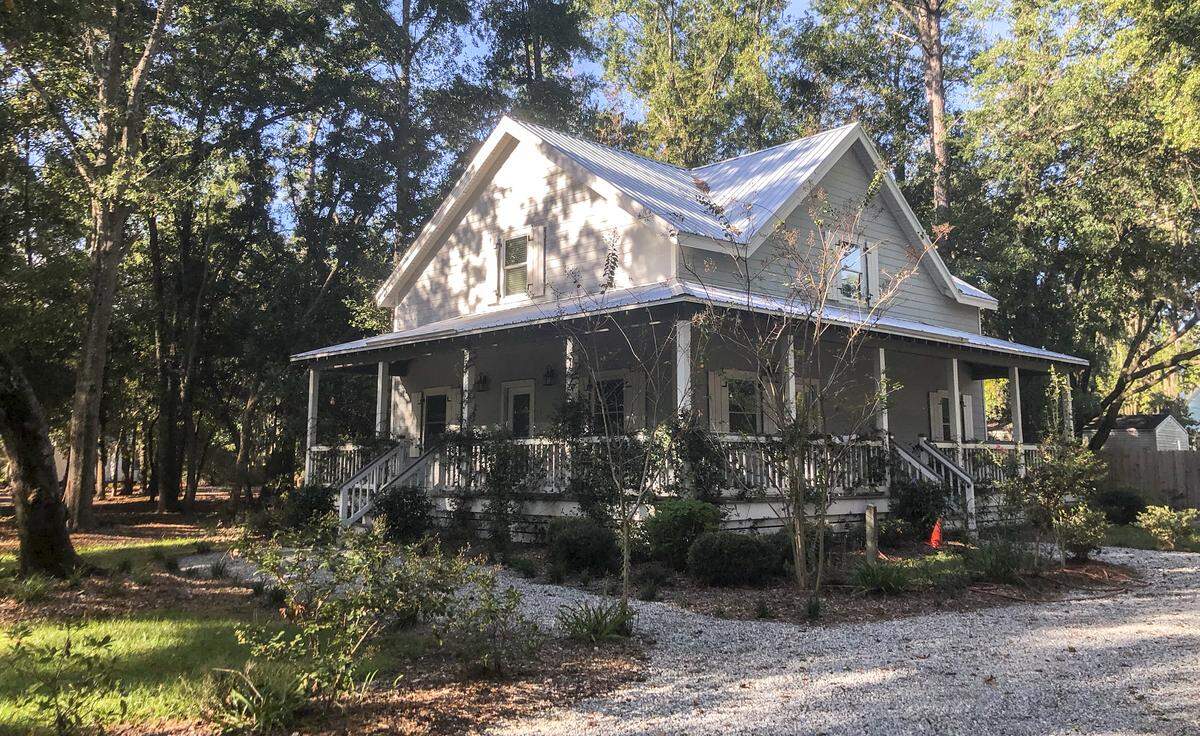 A two-story gray and white home with a wrap around porch owned by Garfield Moss’ eldest daughter serves as a model for how the 12 homes will look. Moss said his 4 acres of land — shrouded from from surrounding streets by a thick layer of trees — is “Bluffton’s best kept secret.”