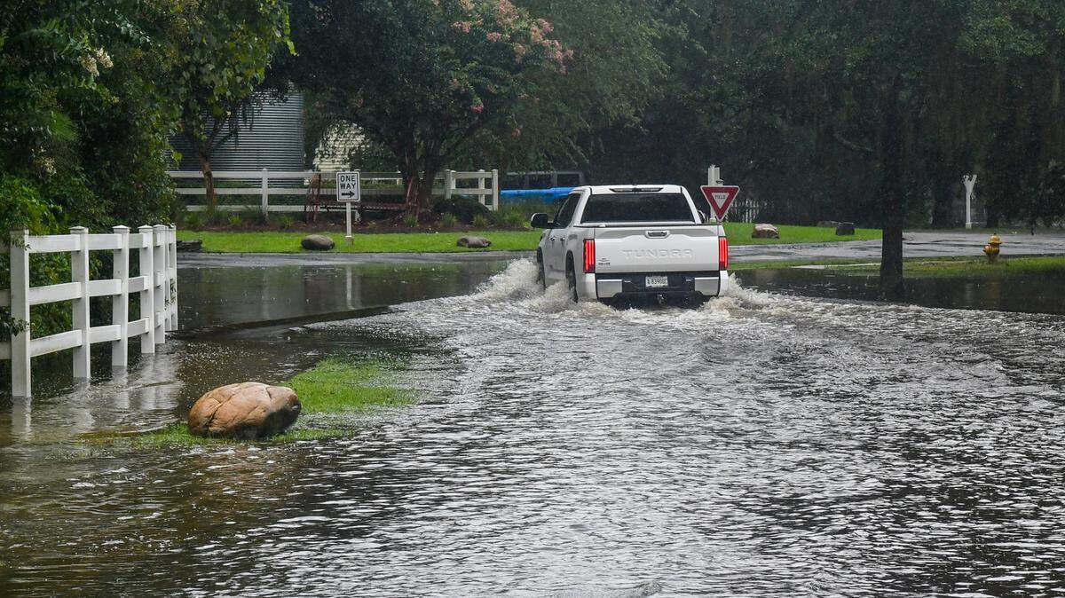 A truck barrels through flooded Old Bridge Drive on Aug. 6, 2024, at The Farm in Bluffton, S.C. after Tropical Storm Debby came through the overnight hours.
