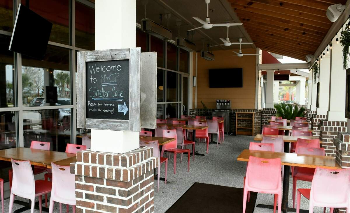 A sign at New York City Pizza on Wednesday, March 18, 2020, informs customers to see a person inside for a table at Shelter Cove Towne Centre on Hilton Head Island. A manager who refused to give his name said they did not have layoffs and that the implemented carry out service only on Tuesday, the day before the governor order restaurants and bars to close their seating.