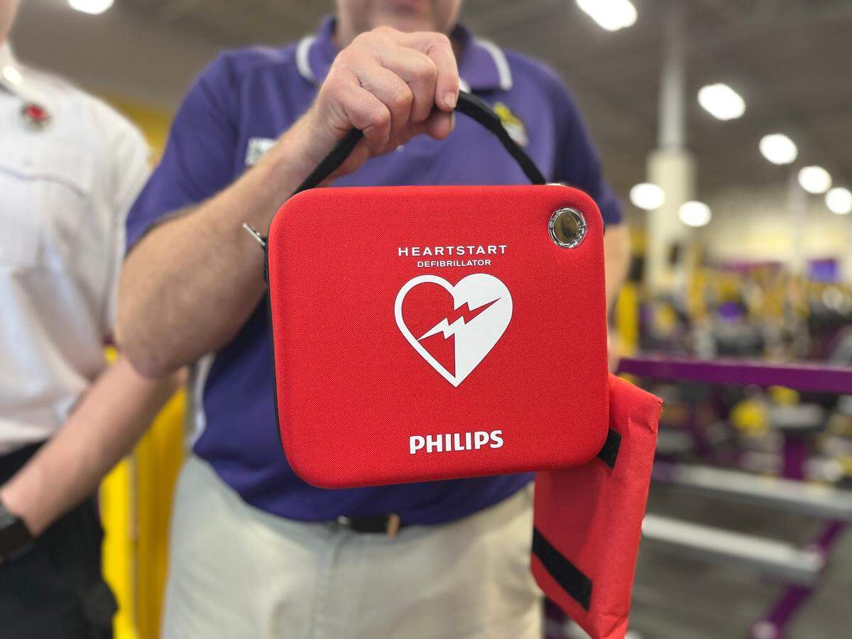 Martz holds up the AED machine that the gym has on hand for emergencies such as the one that took place Tuesday when a man went into cardiac arrest and needed CPR.