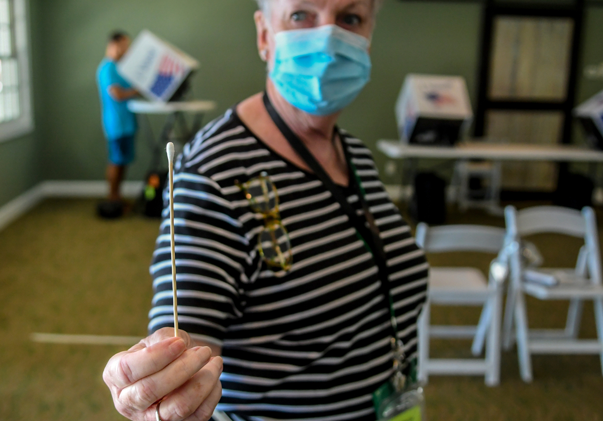 Kathy Alven, poll manager at the Spanish Wells Club, displays a cotton swab on Tuesday, June 9, 2020, used to help reduce the spread of the coronavirus. “Once people realize we’re not testing for COVID-19, they’re fine” with using them, Alven jokingly said through a face mask. The Board of Voter Registration and Elections of Beaufort County decided that disposable cotton swabs should be used to vote on the touch screens rather than voters’ fingers.