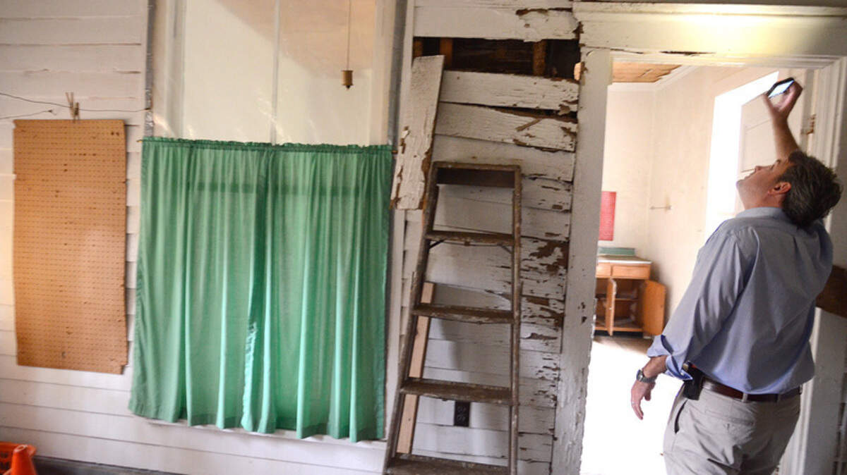 In this file photo, Michael Hahn, co-owner of the Graves House in old town Bluffton, inspects some of the damage to a door frame as he makes his way through the home. Hahn wants to sell the property and the 104-year-old house to Bluffton United Methodist Church, which wants to tear down the house and build a replica in its place.