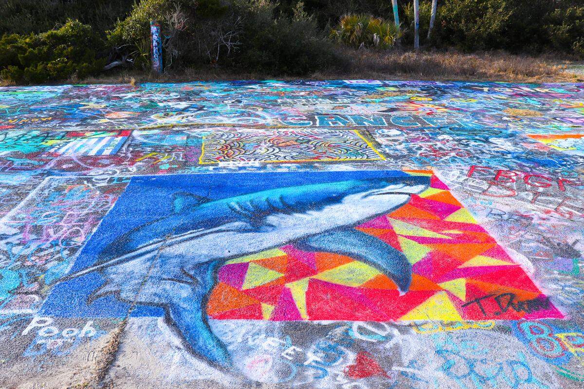 Art, or graffiti? Lighthouse Inlet Heritage Preserve was established in 2009 on the site of a former U.S. Coast Guard station. The paved access road that serves as a walking path has been an attractive canvas for the blooming talents of some local artists. While some residents and visitors dislike the defacement, many visitors enjoy the colorful work, that seems to offer a form of expression that minimizes impact to the surrounding natural areas.