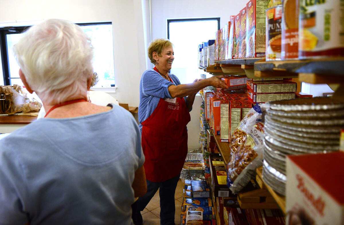 Jill Bearson, a volunteer, stocks the shelves at Bluffton Self-Help on Tuesday afternoon before the first of their three Thanksgiving Food Distribution hours in Bluffton.