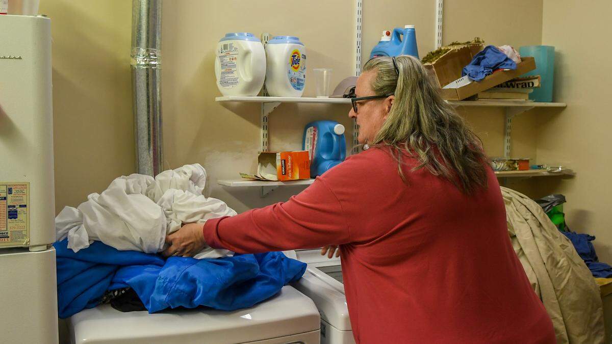 Alissa Murrie, a shelter coordinator at Sea Island Presbyterian Church, moves linen from the clothes washing machine that can be used by those seeking refuge from bad weather when the facility opens as a cold weather shelter.