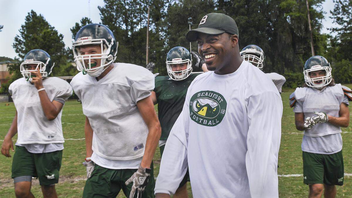 Beaufort High School head football coach DeVonte Holloman shares a laugh with his players at the end of a spring practice in 2018. Holloman credits Beaufort players for helping him “fall in love with football again.”