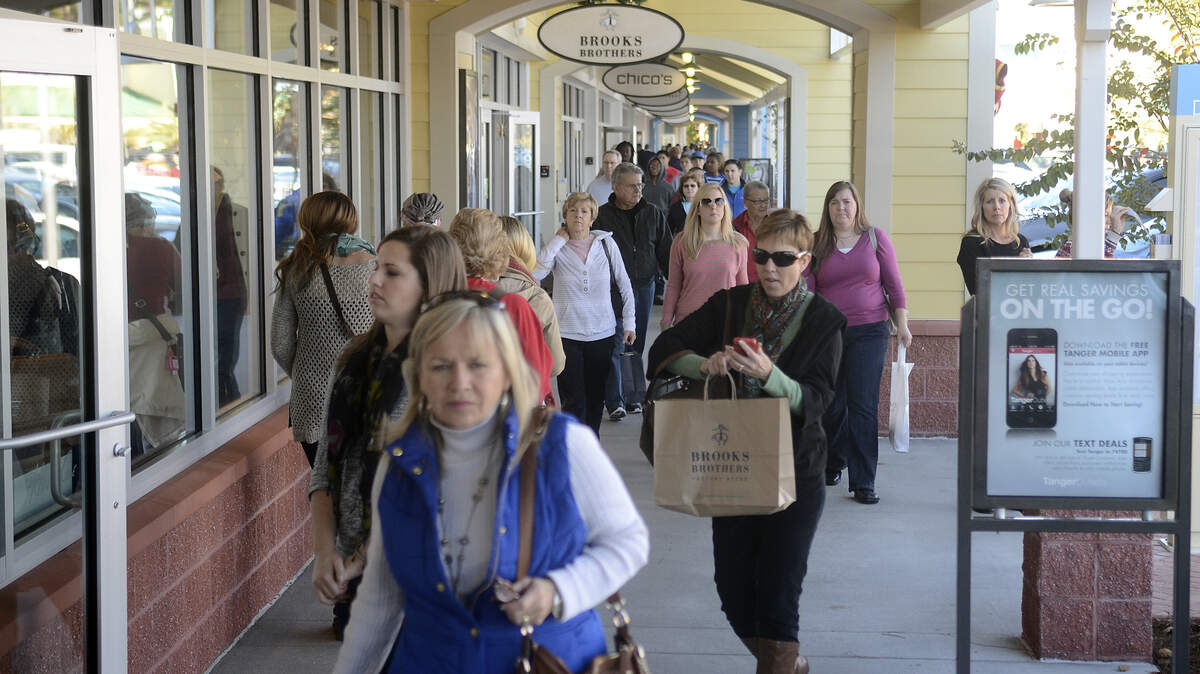 Shoppers walk from store to store looking for Black Friday sales on Friday afternoon at the Tanger 1 Outlet Mall in Bluffton.