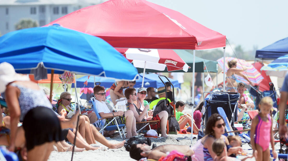 FILE: Beachgoers hang out in their big pop-up tent along Coligny Beach on Aug. 5, 2015.