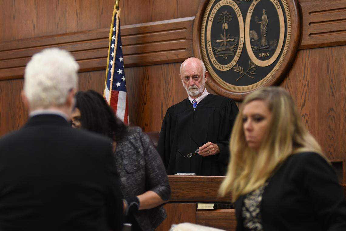 Judge Brooks Goldsmith looks out into his courtroom as defense attorney Trasi Campbell, chief public defender with the 14th Circuit Public Defenders Office, left, and Hunter Swanson, lead prosecutor of the special victims unit at the 14th Circuit Solicitor’s Office, right, discuss evidence admitted in the 2018 trial against Isaiah Gadson Jr..