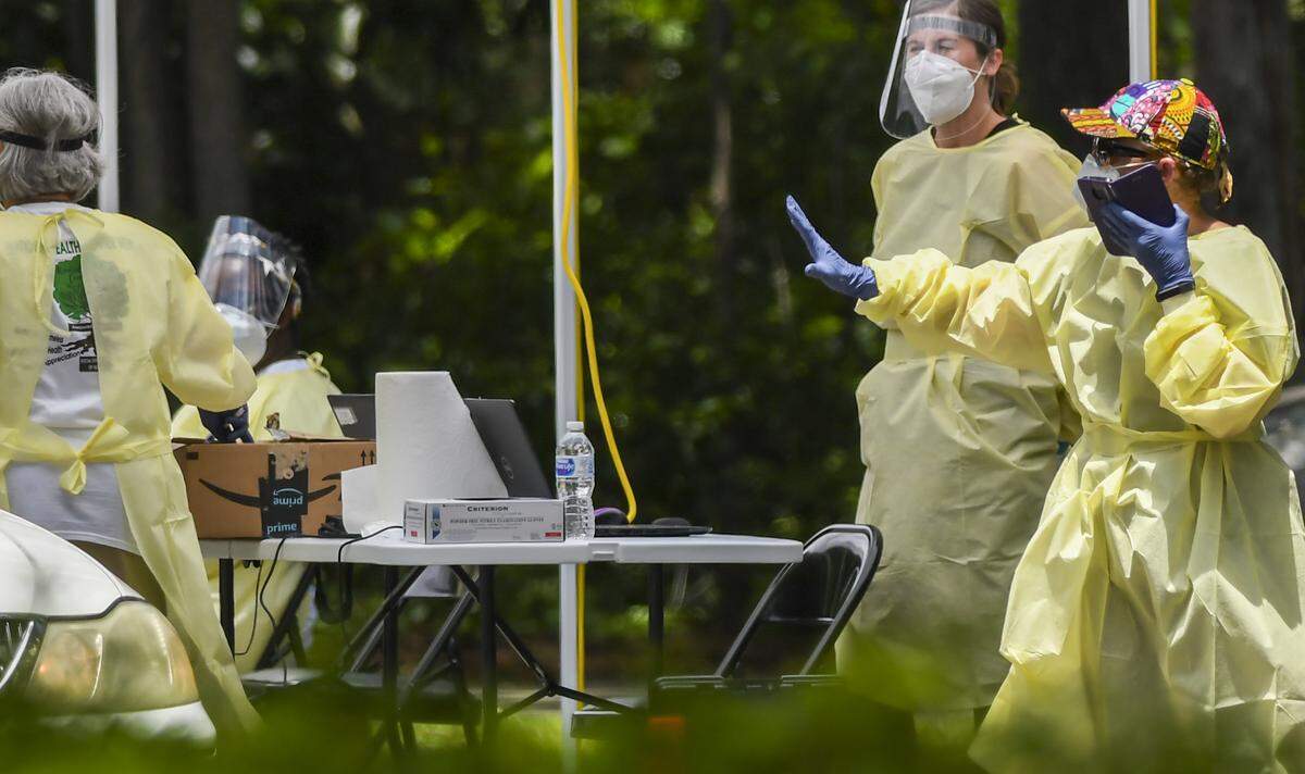 A worker directs a car to stop the free COVID-19 test site on Thursday, May 28, 2020 at the Elijah Washington Medical Center in Sheldon. While many came without registration, Mark Spurling, chief tech officer for the Beaufort Jasper Hampton Comprehensive Health Services said the center had 170 registered patients.