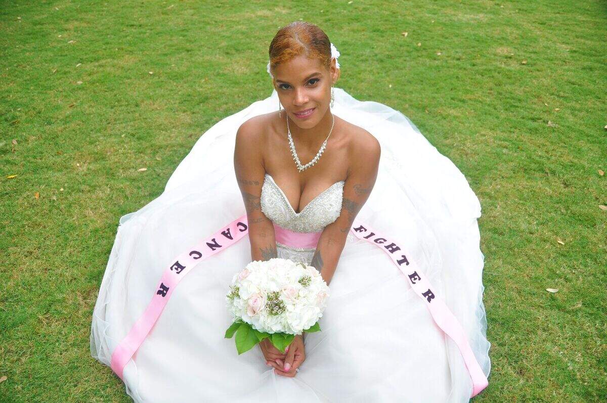 Zully O’Conner Suarez-Hall poses in her wedding gown, which has a pink ribbon around it that says “cancer fighter.” O’Conner Suarez-Hall and her husband Ray had a photo shoot days before she underwent breast cancer surgery.