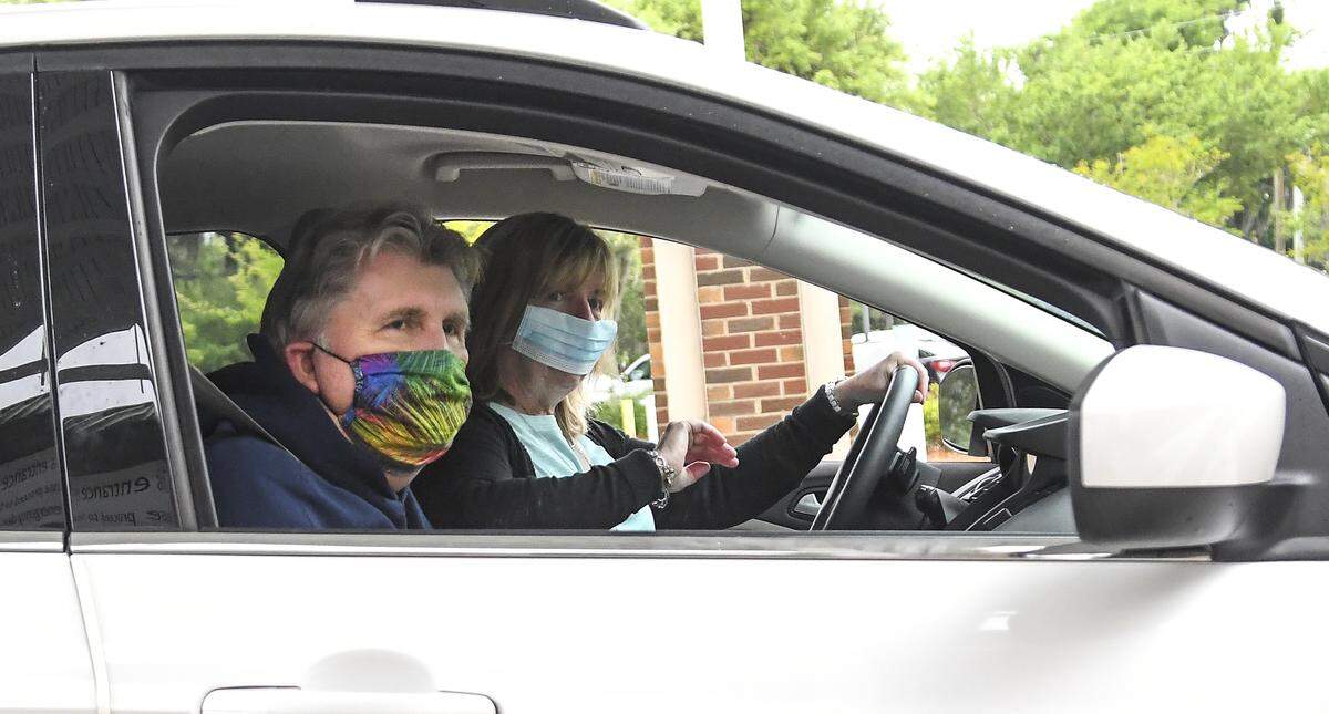 Beaufort residents David Jackson, left, a survivor of COVID-19, is driven away from Beaufort Memorial Hospital on Wednesday, April 15, 2020 as his wife, Rebecca Jackson, starts to wave to the physicians and nurses that saved her husband’s life. David Jackson left the hospital after a months long battle with the coronavirus.