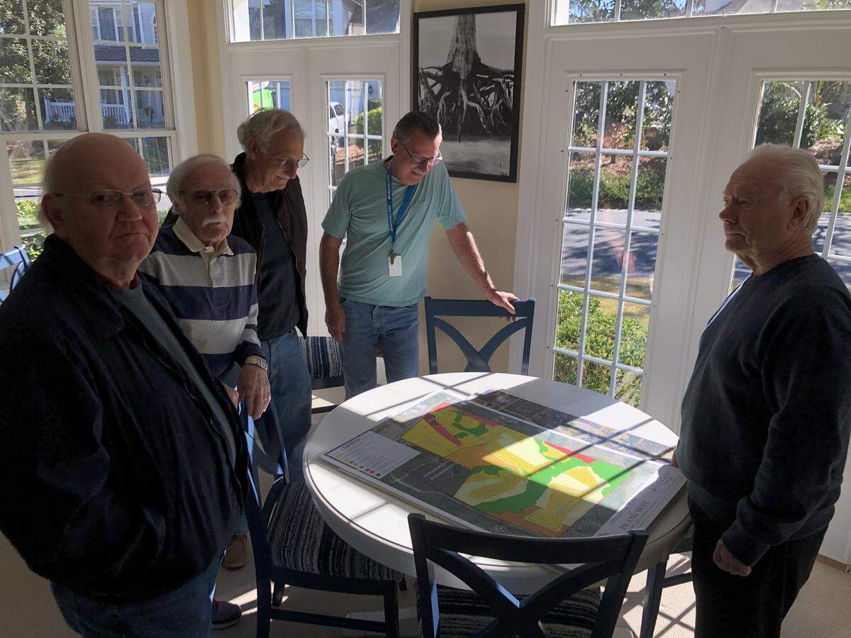 Members of the Island West Committee to Stop Rezoning look at the potential rezoning plans for the Island West Golf Course.