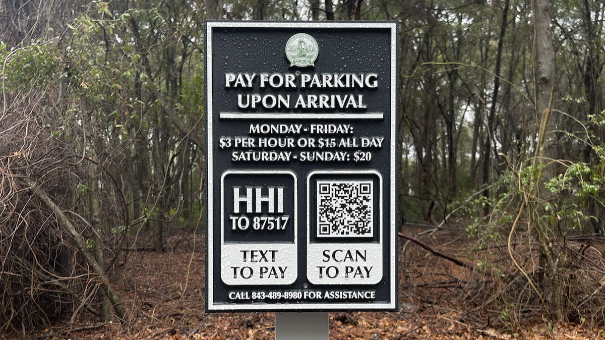 Signs labeled “Pay for parking upon arrival” are scattered throughout Fish Haul Beach’s parking lot on Monday, March 10. Beach goers have the choice of texting “HHI” to the number posted or scan the QR code from their phone’s camera to start the payment process.