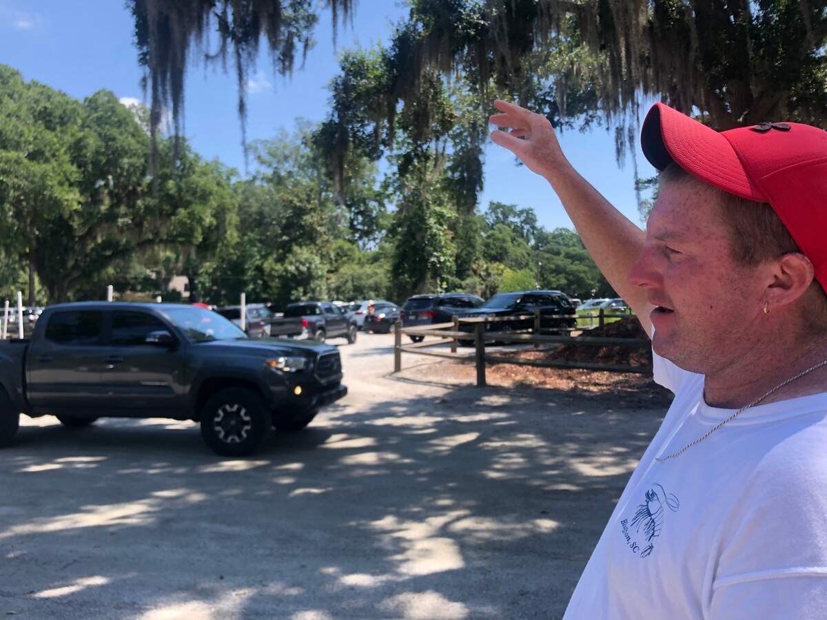 Jeffrey Gainey waves on a truck in the Bluffton Oyster Factory boat landing parking lot. Gainey volunteers to direct traffic at the boat landing all weekend from 7 a.m. until sundown.