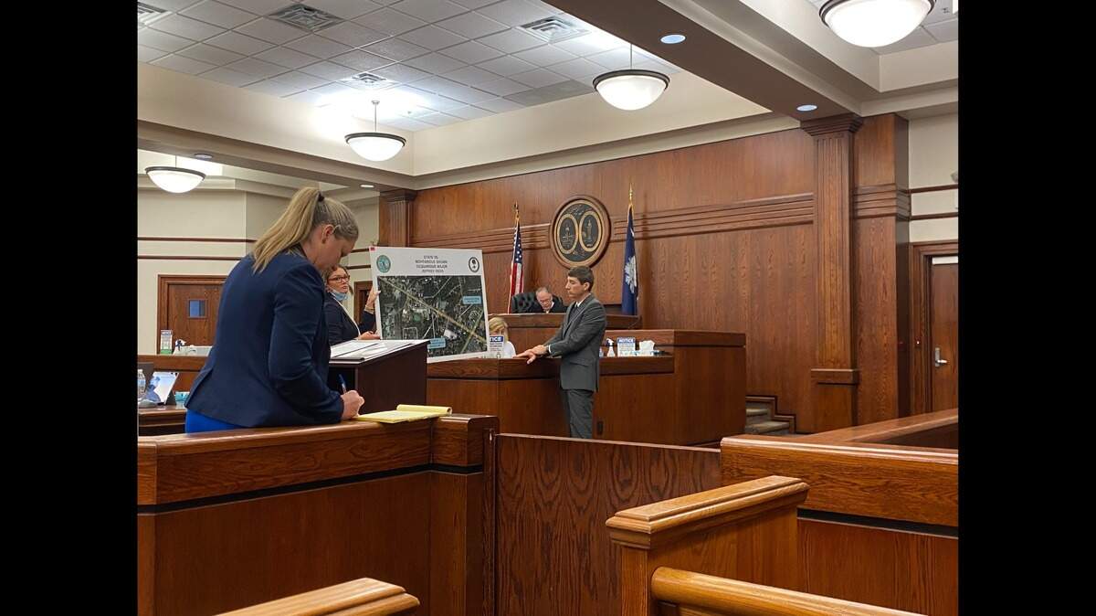 Assistant Solicitor Mary Jones (left) points to a printed map of where a Lady’s Island gas station shootout occurred on Sea Island Parkway on Feb. 14, 2022 at a trial for Jeffrey Redd. Michael Garguilo (right), previously with the Beaufort County Sheriff’s Office, stands next to the map. Judge Robert Bonds (back) presides over the trial.