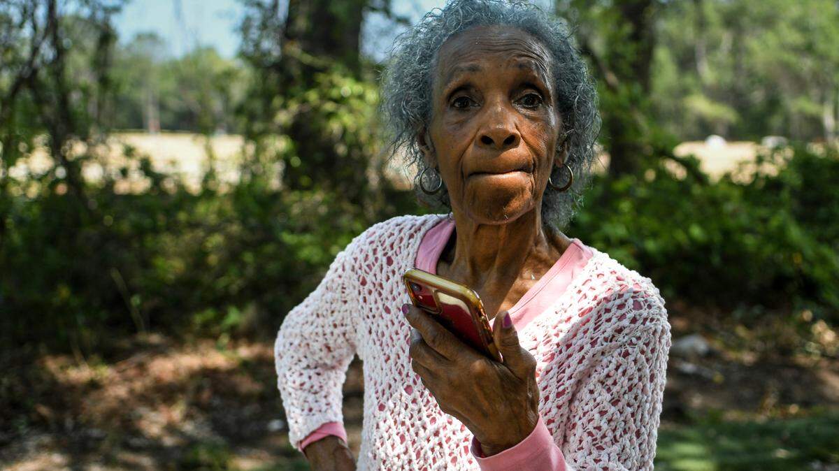 Josephine Wright, 93, stands in her yard while speaking with her granddaughter on speakerphone on May 9, 2023 about their experience as a family with the development company building a residential community surrounding their family land on Jonesville Road on Hilton Head Island.