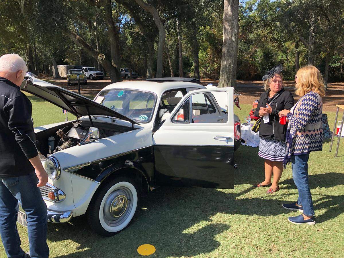 Kathie Foltz of Myrtle Beach, center, chats with attendees next to the 1962 Wolseley 1500 she owns with her husband Richard at Saturday’s Car Club Showcase, part of the Concours d’Elegance on Hilton Head Island.