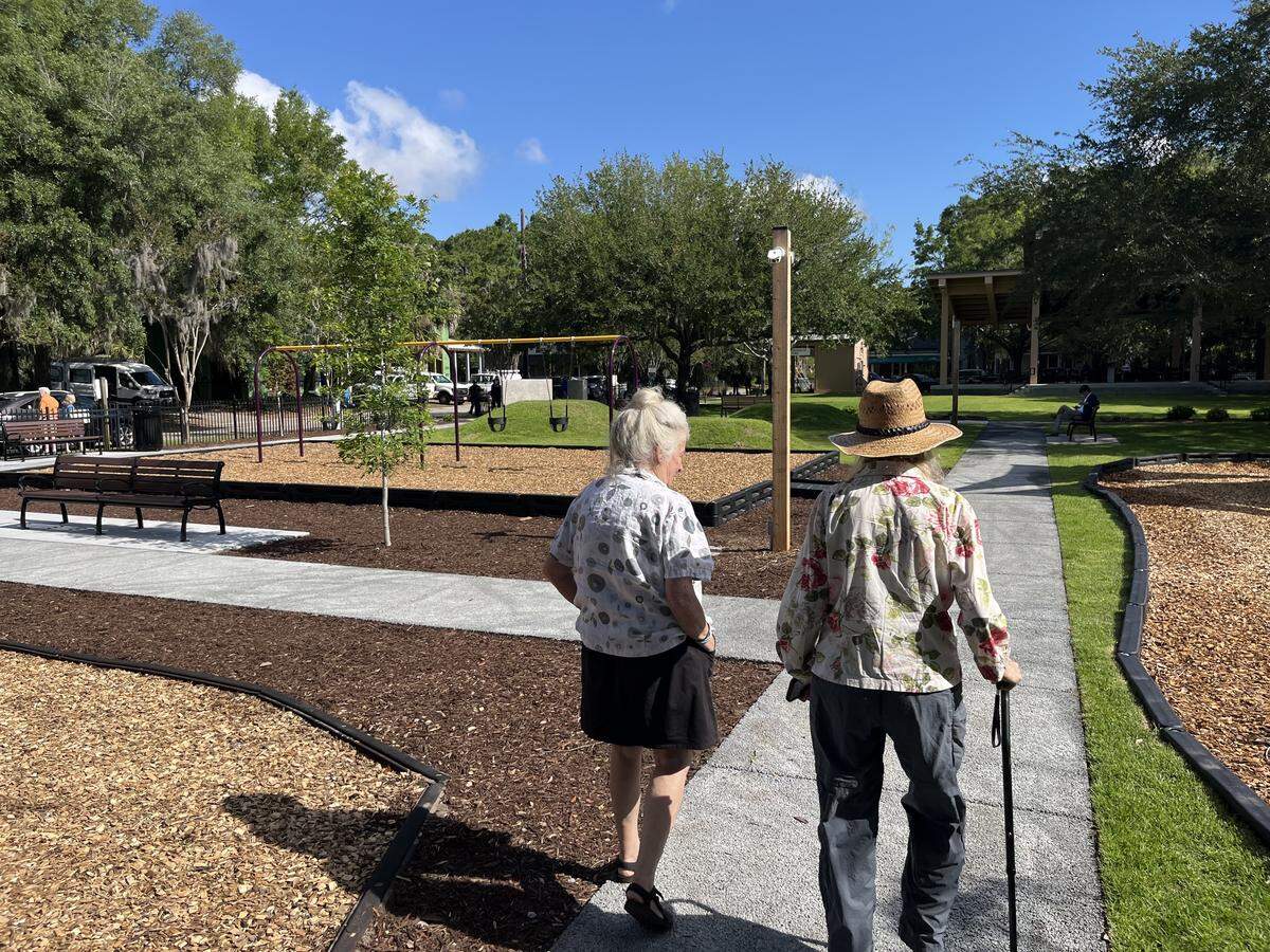 Lolita Huckaby and Carol Tuynman stroll in Washington Street Park Wednesday morning. The park has undergone $1 million in improvements. A new sign also explains the park’s historic significance to the community.