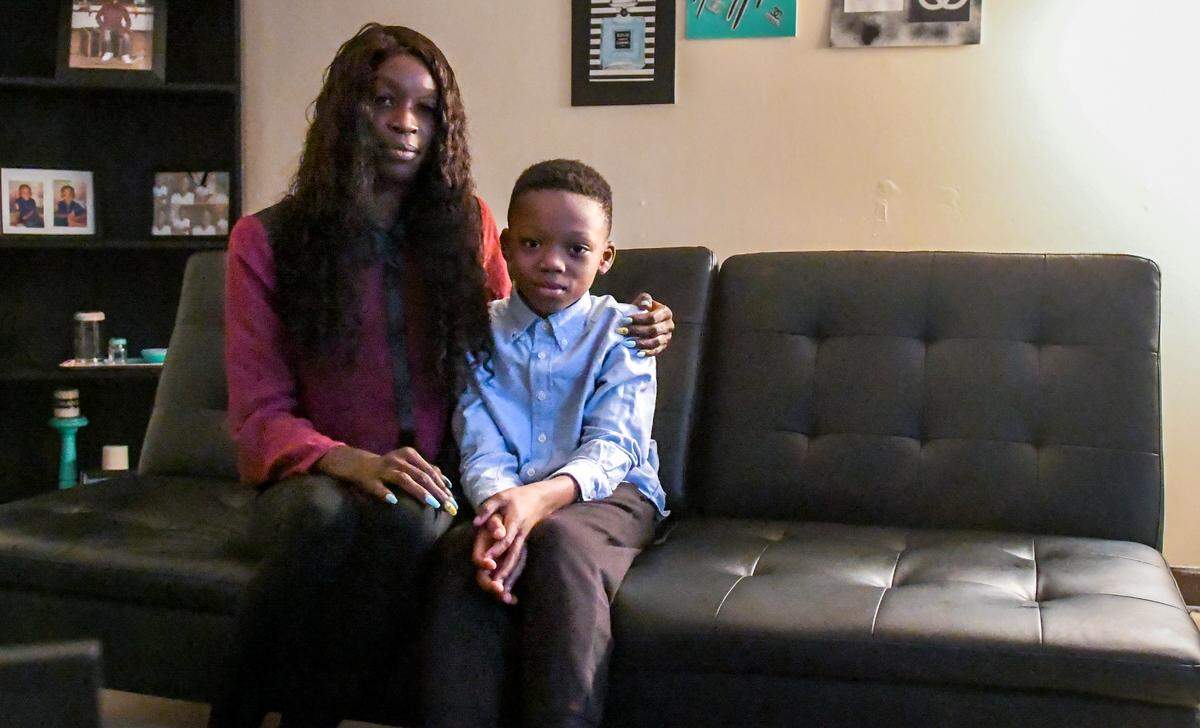 Tiffany Glover, poses with her nine year-old son Quintez on the futon in their living room at their Sandalwood Terrace apartment on Wednesday, Oct. 21, 2020 on Hilton Head Island. Glover and her son sleep on the futon together while the two-bedrooms upstairs have all the items moved into the center of each room because of the roach infestation.