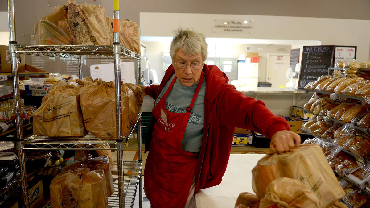 Janis Sanford, a volunteer from Bluffton, loads bags of Thanksgiving food onto shelves at Bluffton Self Help before opening Nov. 24, 2015. The bags were for people unable to make it to the charity last week during special distribution hours to put together a take-home Thanksgiving meal, executive director Lili Coleman said.