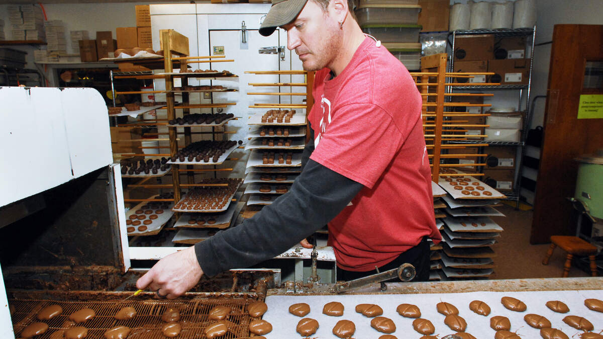 Employees at The Chocolate Tree in Beaufort were busy both making and selling Valentine's Day candy Feb. 13, 2015. Here, co-owner Gene Green keeps the assembly line churning out tiger paws, the caramel and pecan treats that are the store's top-selling Valentine's Day item, he said.