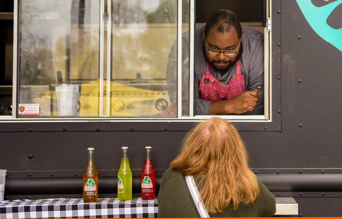 Executive Chef Bernard Bennett talks to a customer from the Okan food truck on Thursday, Feb. 2, 2023, at the Bluffton Farmers Market. Bennett recently was named one of 20 semifinalists in the Emerging Chef category by the James Beard Foundation.