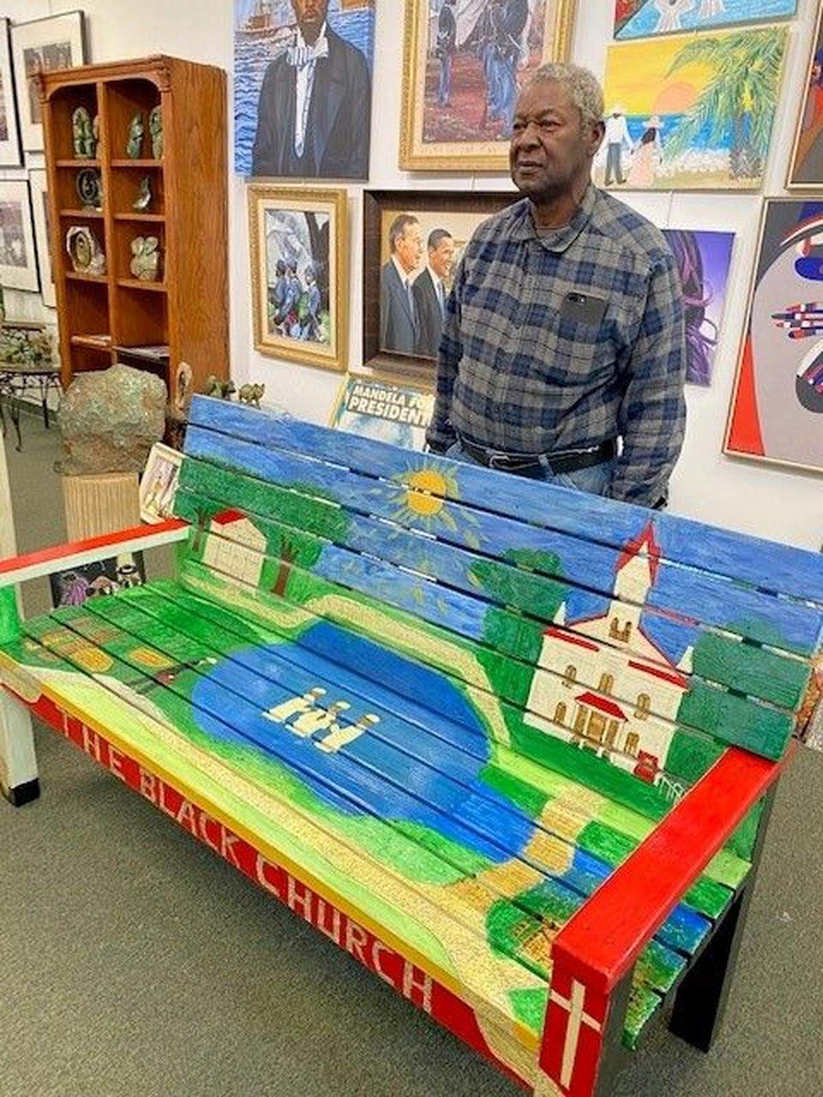 The Rev. Johnnie F. Simmons behind the bench he painted last year entitled “The Black Church.” This memorializes the Tabernacle Baptist Church, which was founded in 1811, and in 1863 became the first Baptist church for African-Americans in Beaufort.