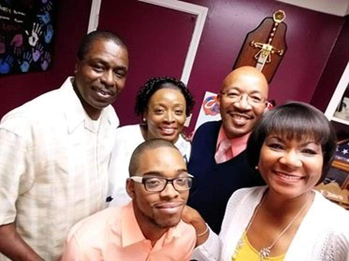 Malik with his parents and pastors of his church.
