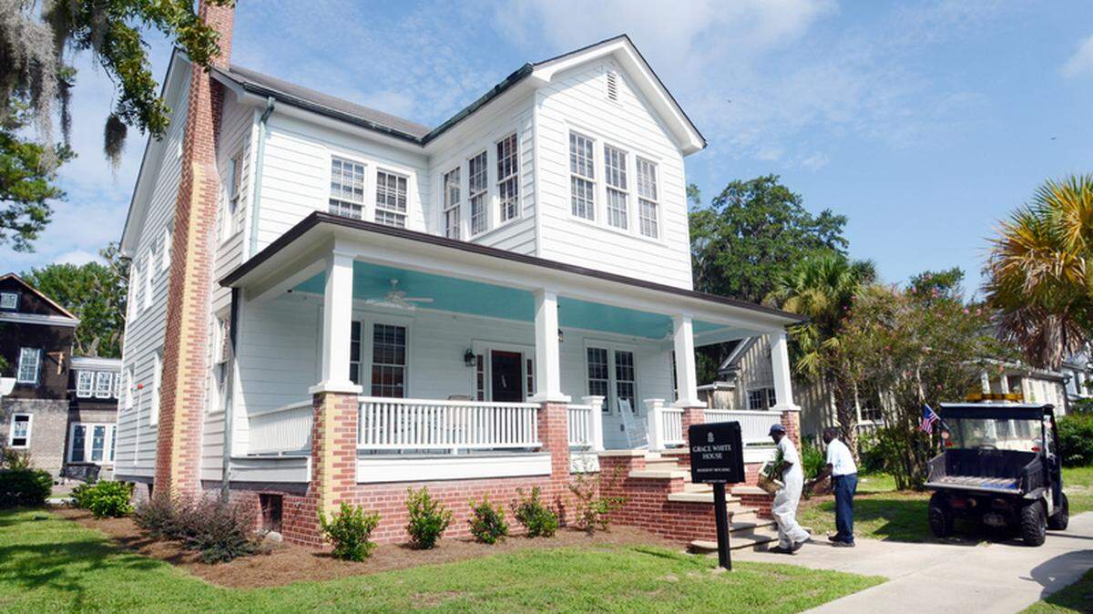 Workmen Jessie Holmes, left, and Earl Mack place planters in front of the University of South Carolina Beaufort's first-ever dormitory in Beaufort on Wednesday. The Grace White House, a converted residence across from the campus on Carteret Street, will house 16 students.