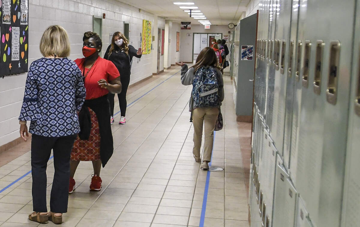 Middle school students wave to each other as they change classes on Monday, Oct. 5, 2020, through the hallways at Beaufort Middle School on the first day of in-person instruction in Beaufort County Public Schools.