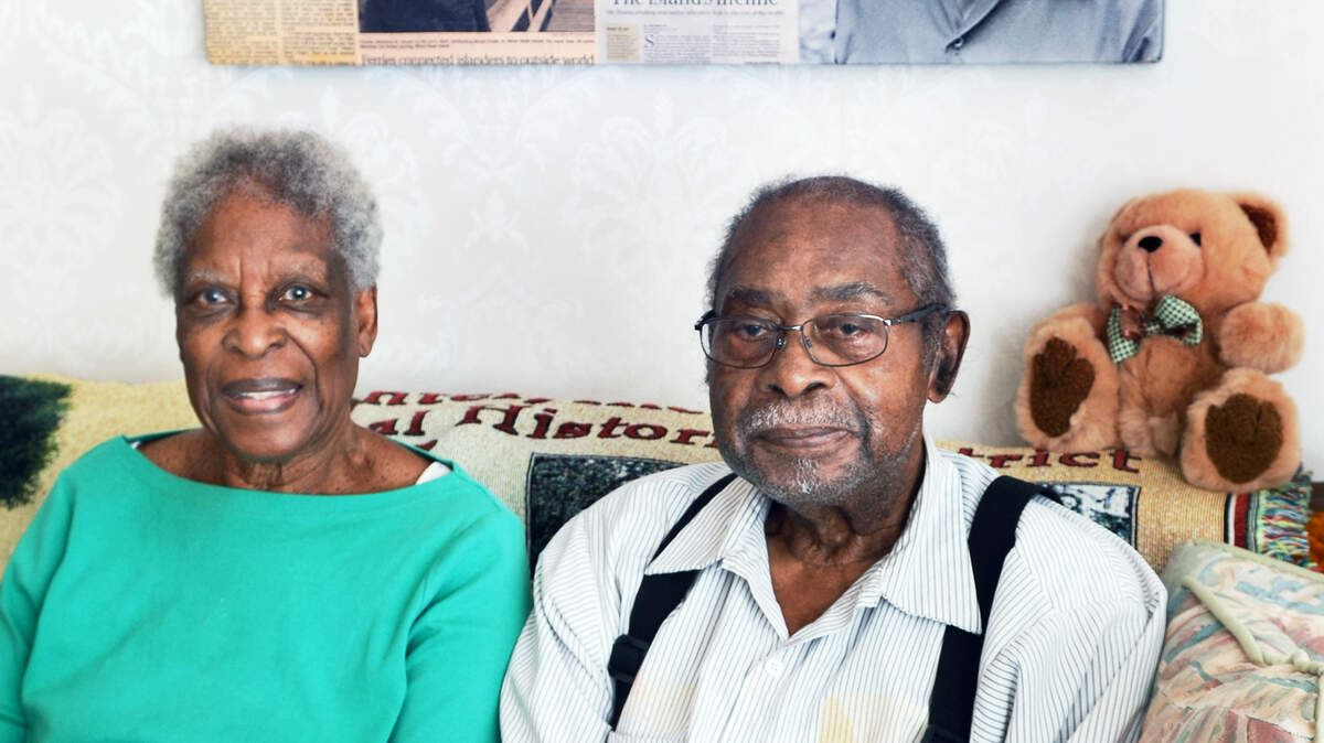 Charles Simmons Jr. and his wife, Rosa G. Simmons, are photographed on Wednesday seated beneath a wall hanging honoring Simmons' father, Charles Simmons Sr. A Hilton Head Island road named for Charles Simmons Sr., a native islander known as "Mr. Transportation" who once operated the sole ferry to Savannah in the days before the bridge to the mainland, has been changed to Silver Moss Drive by the builders of the new Silver Moss development.