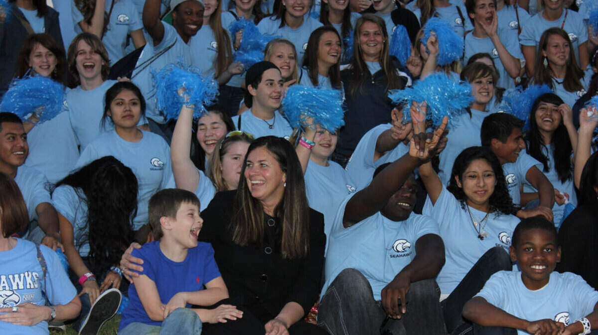 Hilton Head Island High School principal Amanda O'Nan sits surrounded by students after her school won the Palmetto's Finest Award.
