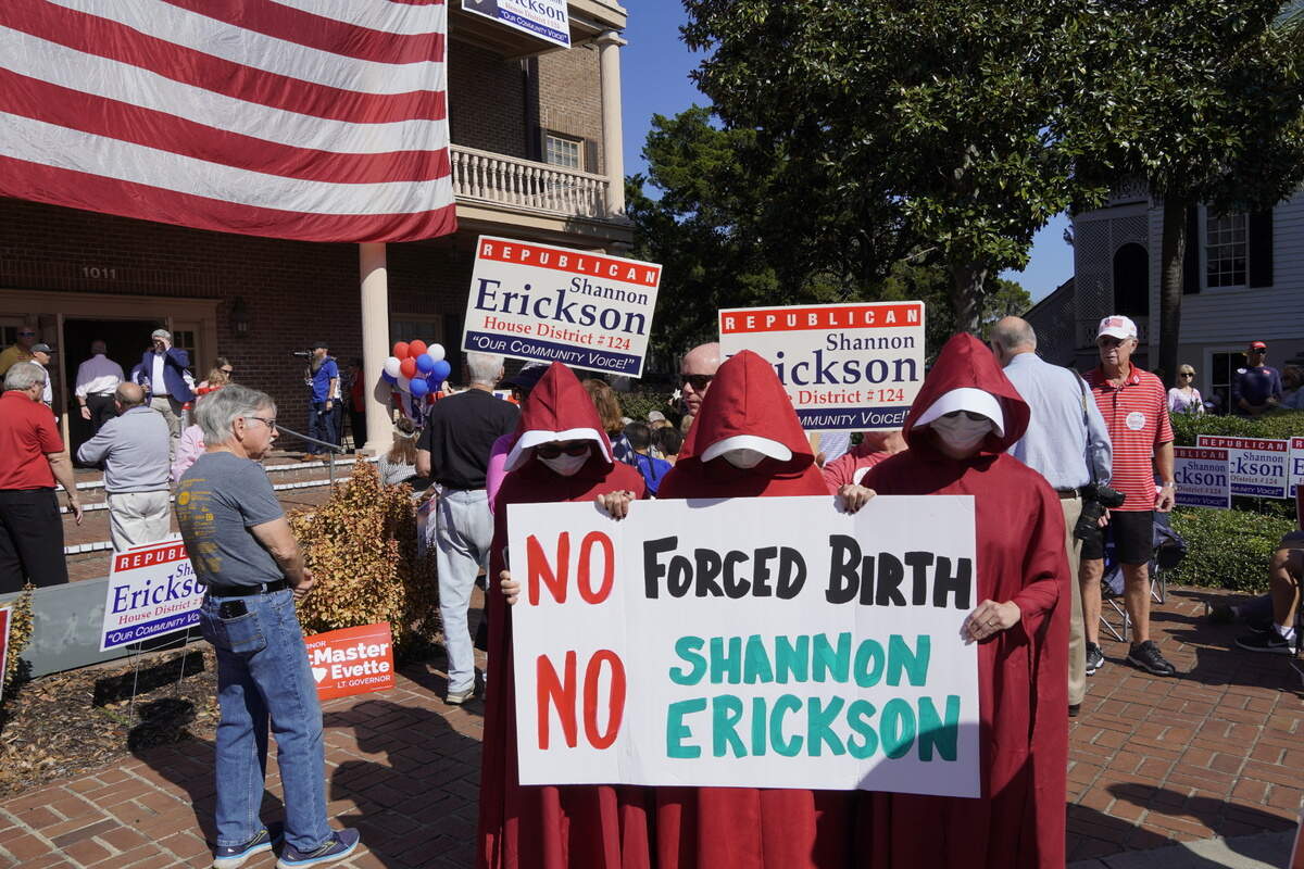 Dressed in familiar outfits from dystopian novel “The Handmaid’s Tale,” three silent protesters spoke out against S.C. House District 124 candidate Shannon Erickson’s anti-abortion voting record.