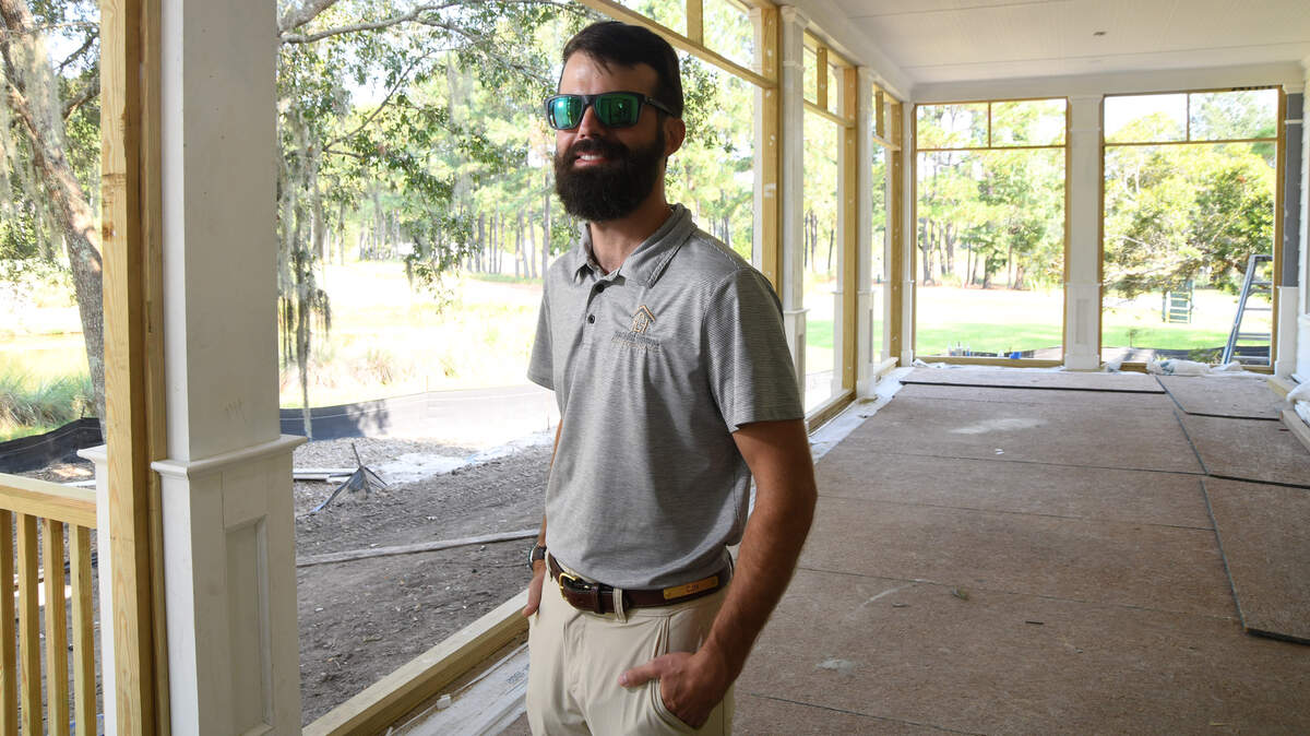Cameron Hackett of Hackett Homes and Construction surveys the work in progress of the outdoor living area overlooking the golf course of a new home he’s building for a client in the Oldfield neighborhood.