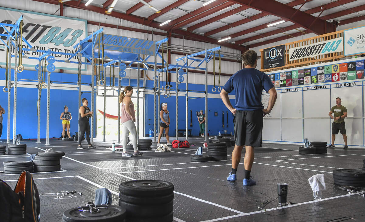 Gym members stand in their 10-foot squares equipped with weights, sanitizer and towel as Martin Catalioto, far right, owner of CrossFit 843 explains the rules on Monday, May 18, 2020, in Bluffton. Monday marked the first day close-contact businesses could reopen after SC Gov. Henry McMaster’s executive order closed them on April 1, 2020 due to the coronavirus.