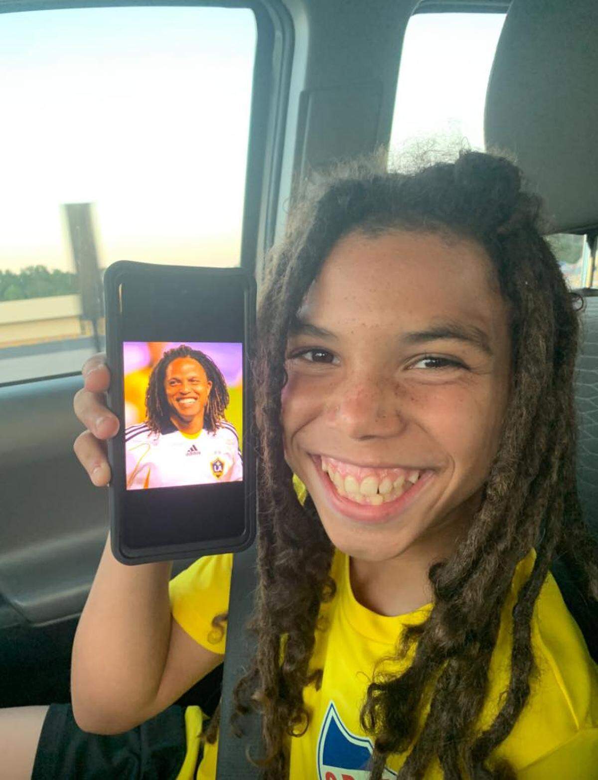 Jerrieme “L.J.” Washington smiles alongside a photo of Cobi Jones, a former professional soccer player from the Los Angeles Galaxy. The 14-year-old was killed in a drive-by shooting the night of Jan. 1 at his home in Burton.