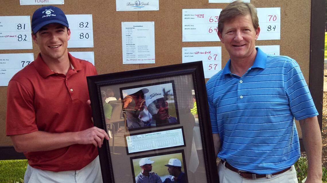 Weston Butler, left, and his father, Drew Butler, pose with the framed print they won in the inaugural Hilton Head Island Amateur Golf Association Father-Child tournament on Sunday. The Butlers shot 76 in the championship flight to edge two teams by a stroke. Derek and Conrad Gall won the first flight with a 57.