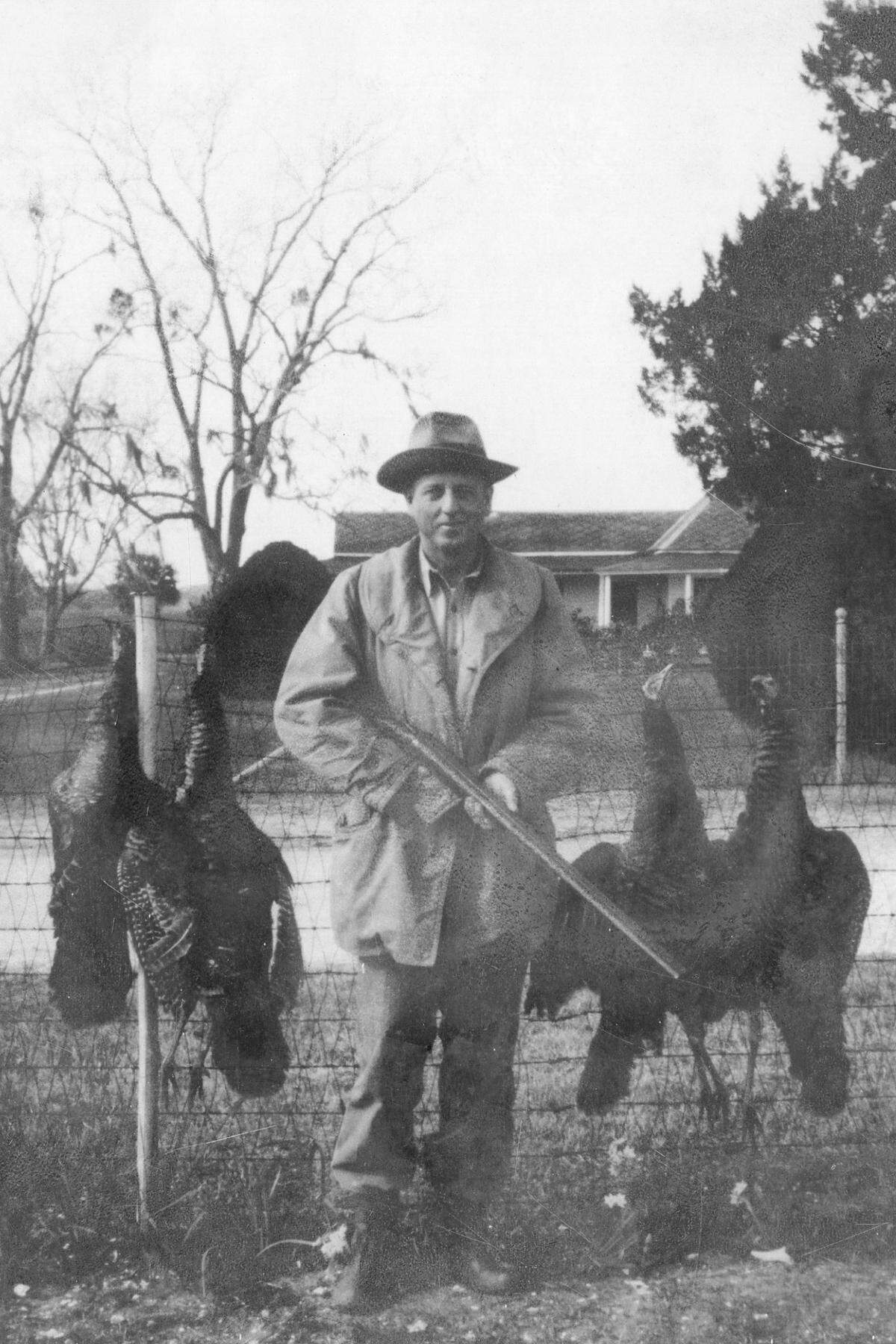Fred C. Hack after a turkey hunt in 1952, with the home of Honey Horn managers Ted and Margaret Lawrence Armstrong in the background.