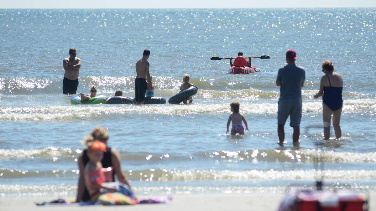 Beachgoers enjoy a dip in the Atlantic Ocean at Coligny Beach Park on Oct. 14, 2015. Down the beach near the Shipyard Beach Club, a young girl was injured on the arm by what observers believe was a shark bite.