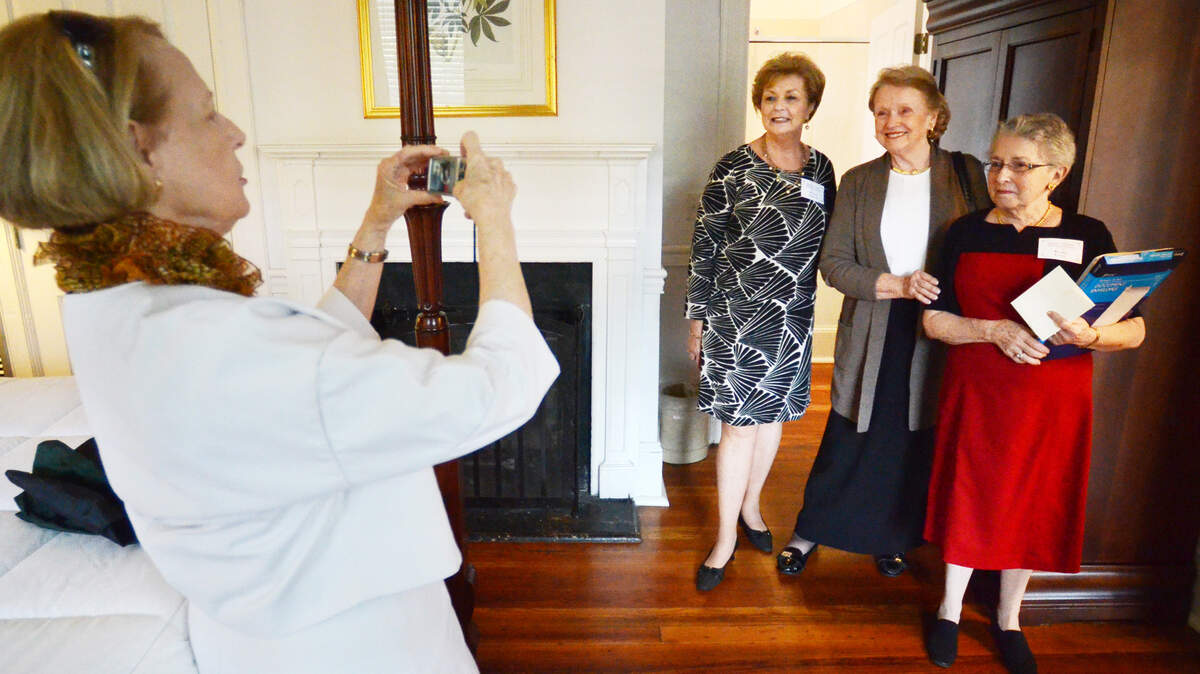 From left, Joan Easterling, of the Beaufort Female Benevolent Society, takes a picture of fellow members Wanda Scheper, Marjorie Trask and society president Renee Levin as the group tours a house at 700 Scott Street -- now part of the Beaufort Inn -- that the society once owned. The society, founded in 1814 to educate and provide relief for destitute children, is celebrating its 200th anniversary.