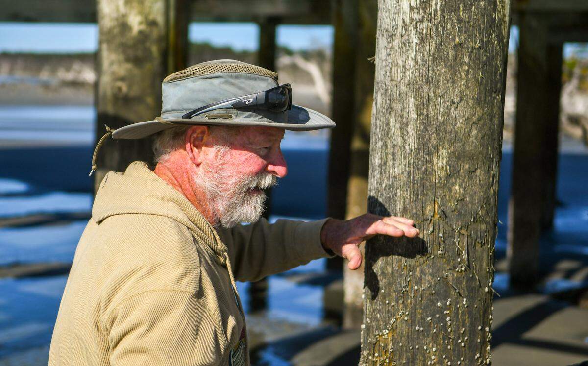 Robert Morris, a Beaufort native who has been visiting Pritchards Island his entire life, uses his hand on Friday, April 8, 2022 to mark where the high tide now meets the abandoned USC laboratory formerly used for coastal research and the study and preservation of loggerhead turtles.
