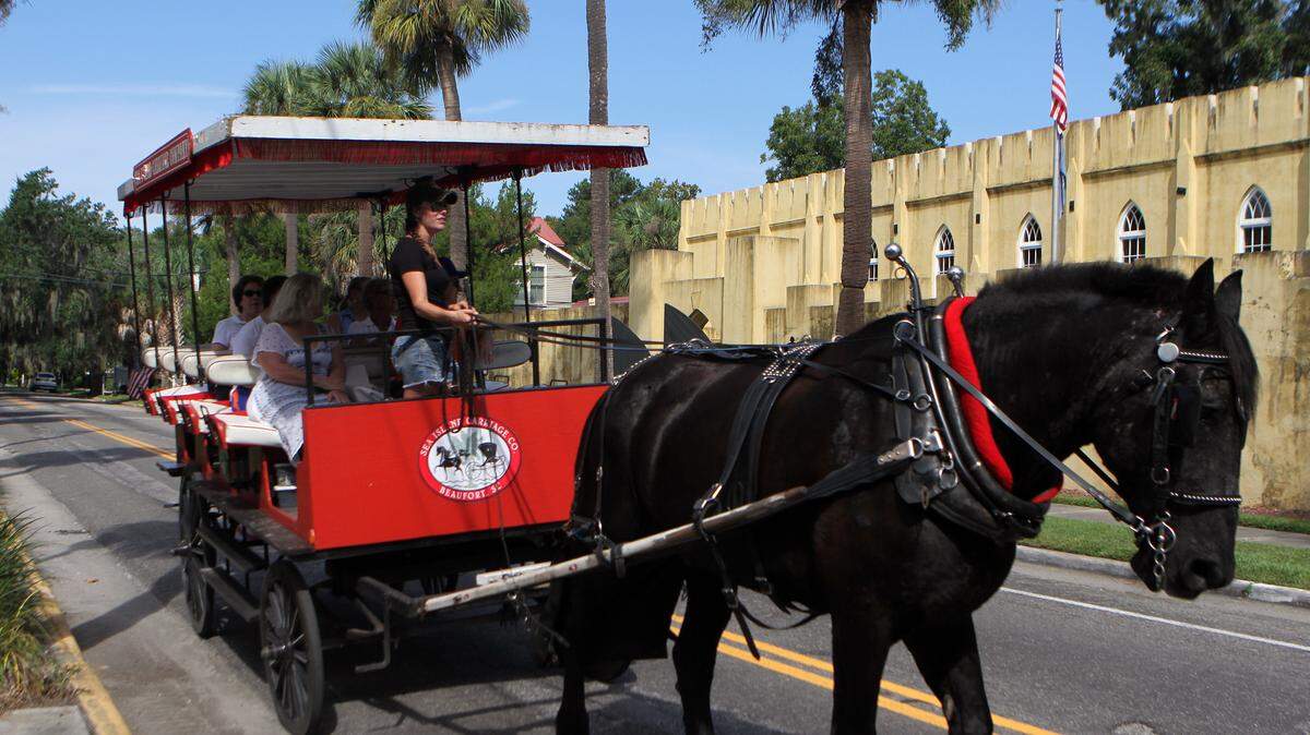 A tour group with Sea Island Carriage Co. passes by the Beaufort Arsenal on Craven Street in Beaufort.